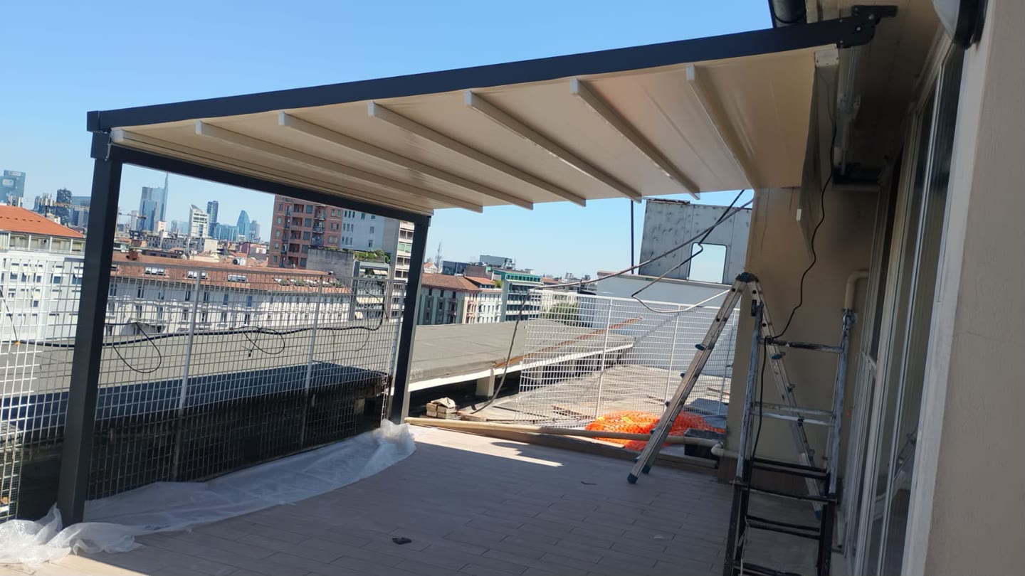 Pergola retrattile installata su un attico a Milano con vista sullo skyline
