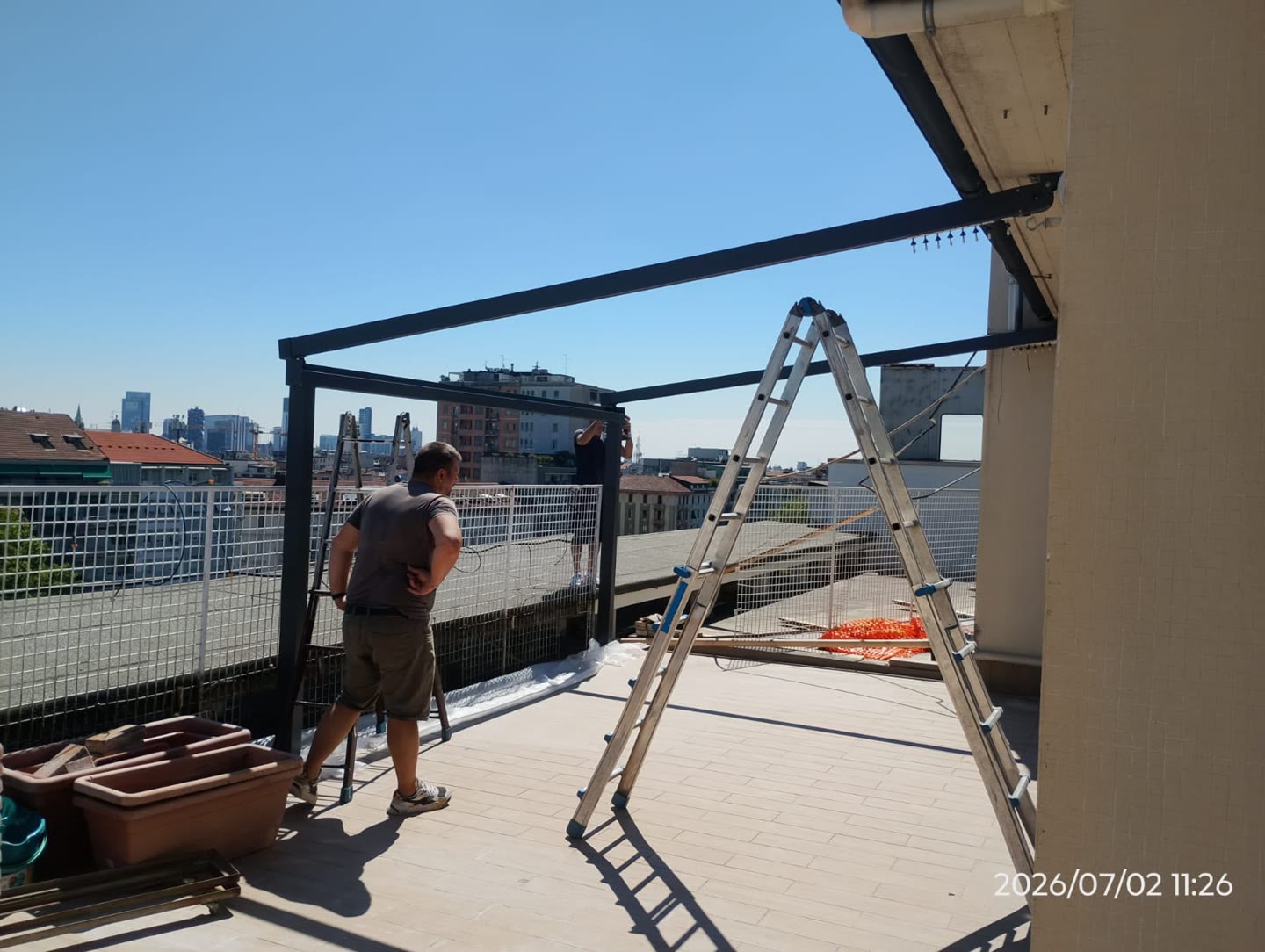 Montaggio della struttura in alluminio di una pergola su un terrazzo a Milano